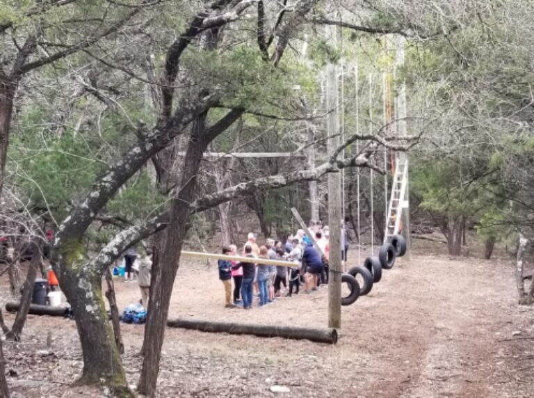 Group at outdoor ropes course with tire swings