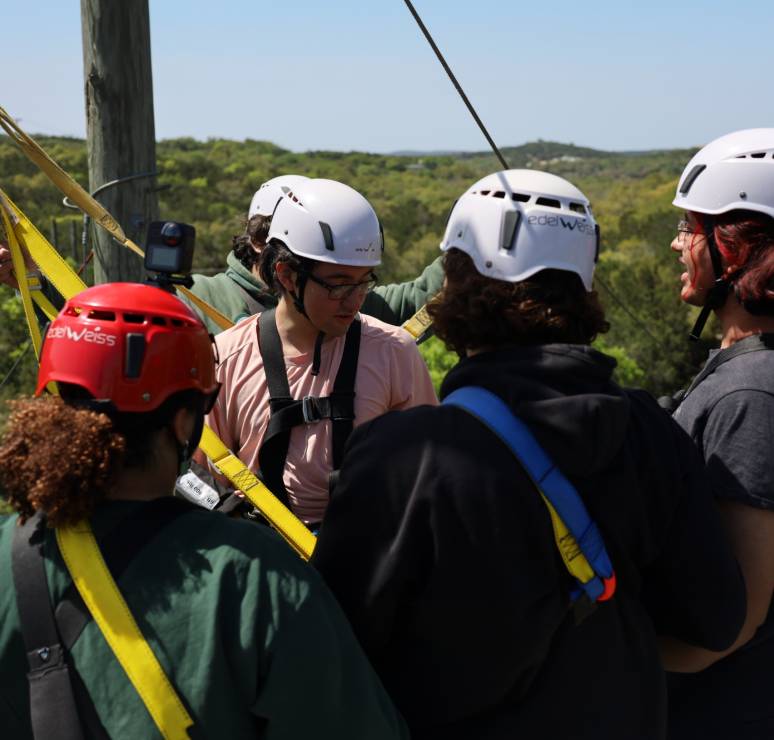 Group preparing for zipline with helmets