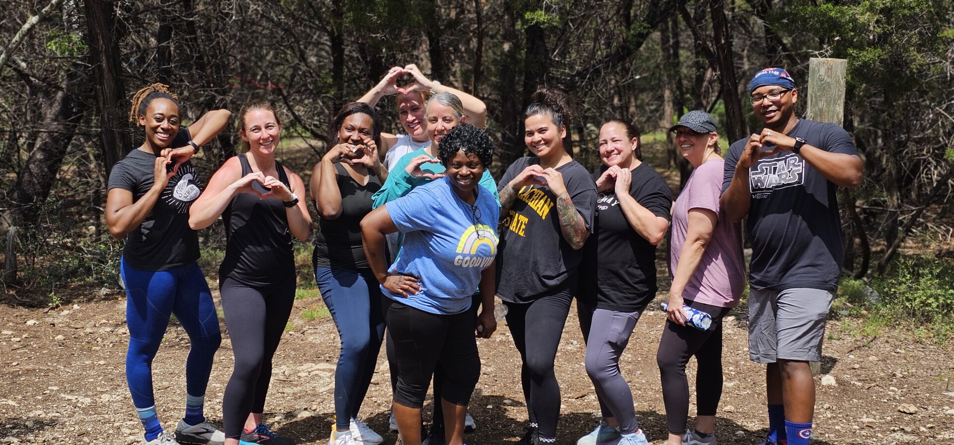 Smiling group outdoors forming heart hand gestures