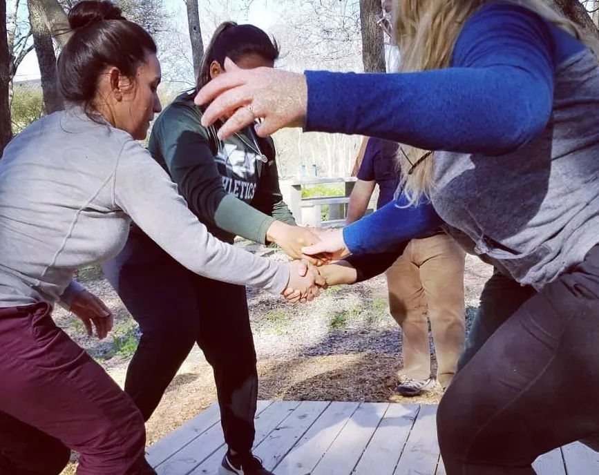 Group participating in outdoor team-building hand stack