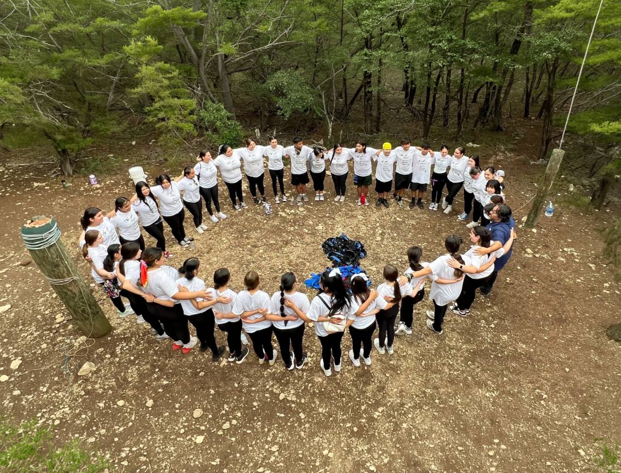 People in white shirts forming outdoor circle