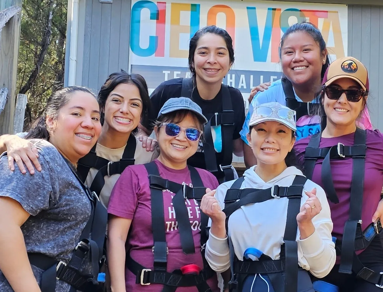 Smiling women wearing harnesses at adventure park