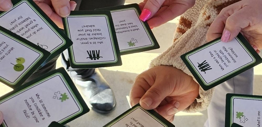People holding green-bordered question cards